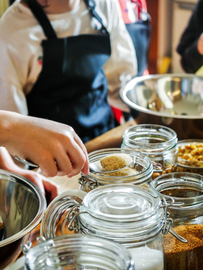 Children participate in a fun baking workshop, measuring ingredients in a kitchen setting.